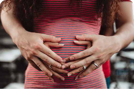 a couple with hands on a pregnant belly