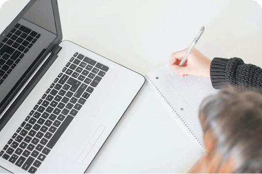 A person writing a draft of a thank you letter