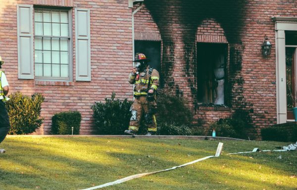 Firefighter walking out of a house