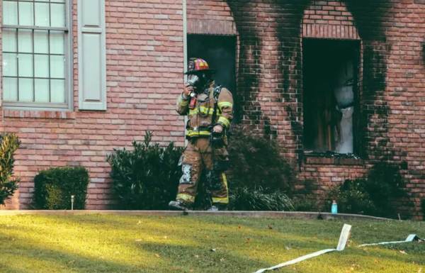 Firefighter walking out of a house