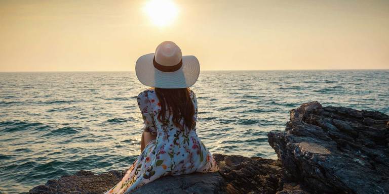A woman looking out at a sunset