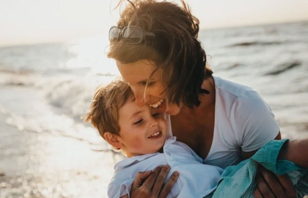 A mother playing on the beach with her son