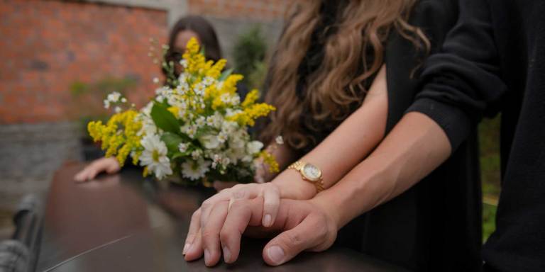 supportive hands on a coffin