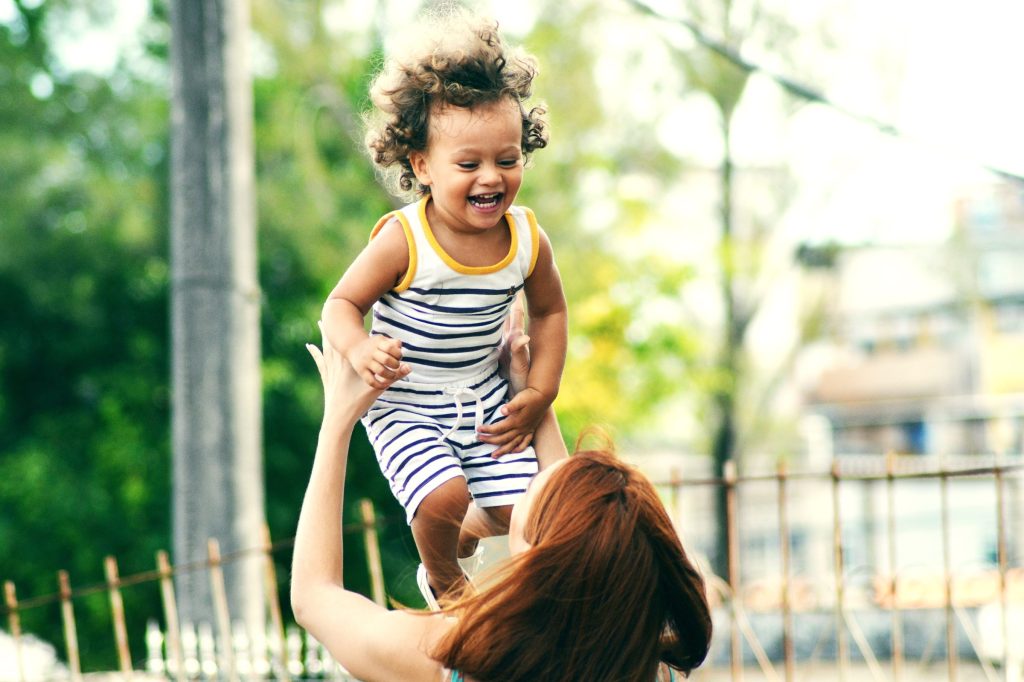 Woman holding up a small child