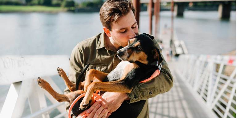 A pet owner holding up his rescue dog