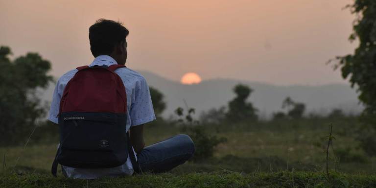 A man looking out at a sunset