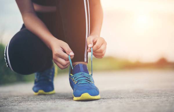 A woman tying her running shoes