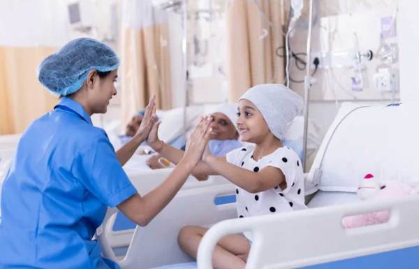 A doctor holding the hands with a young patient