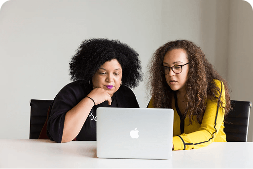 Two women updating a fundraiser using a laptop