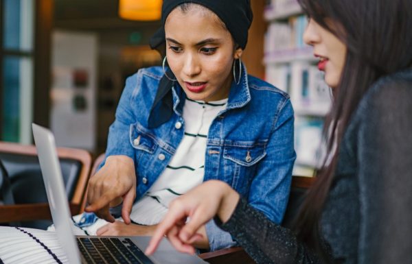 Two women working on a laptop