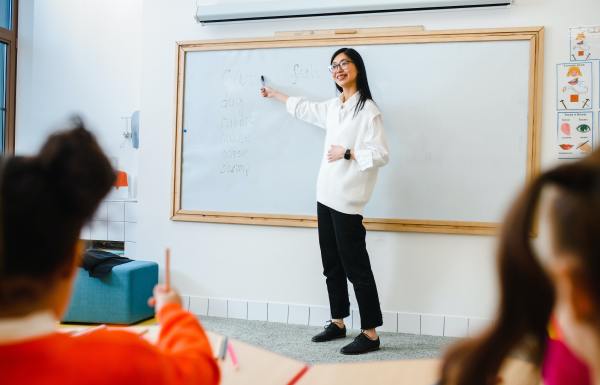 A teacher in front of a whiteboard in a classroom