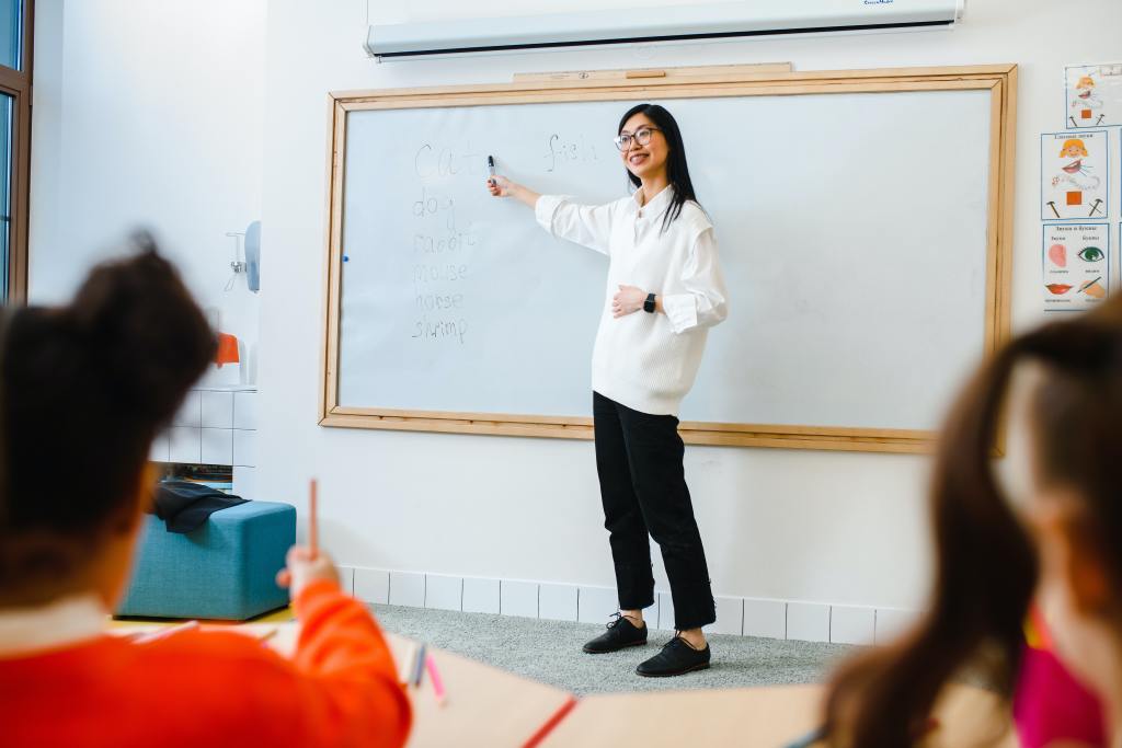 A teacher in front of a whiteboard in a classroom