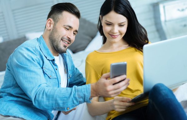 Relaxed couple looking at photos on smartphone