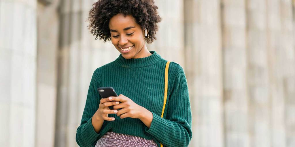 A woman posting an update on her cellphone
