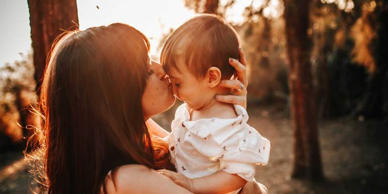 A mother kissing her son on the nose