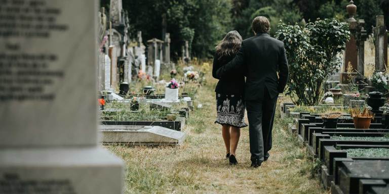 People walking through a cemetary