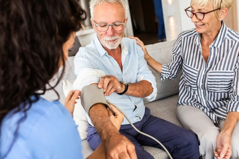 Hombre al que un médico le mide la presión arterial