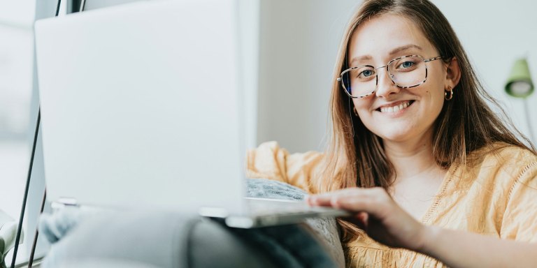 Una mujer sonriente frente al ordenador