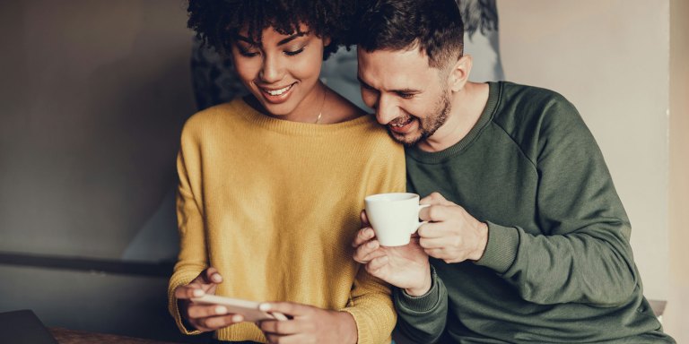 Una pareja actualizando su recaudación de fondos con su teléfono