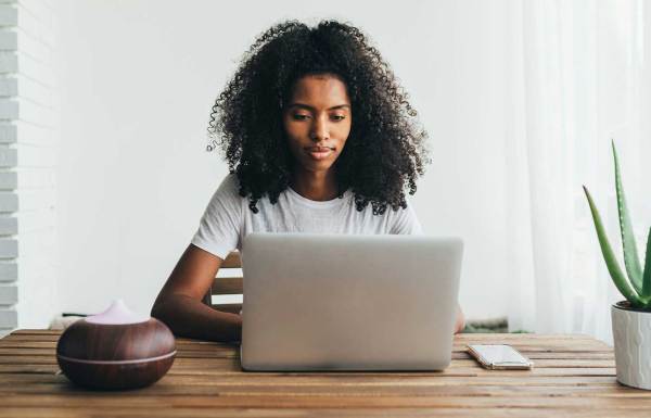 Une femme utilisant un ordinateur portable pour mettre à jour sa campagne de financement