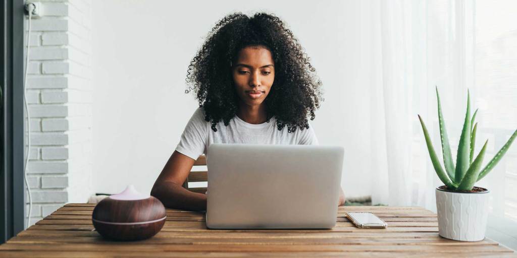 Une femme utilisant un ordinateur portable pour mettre à jour sa campagne de financement