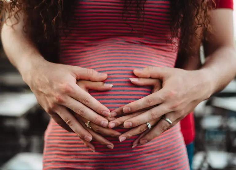 un couple tenant le ventre d'une femme enceinte