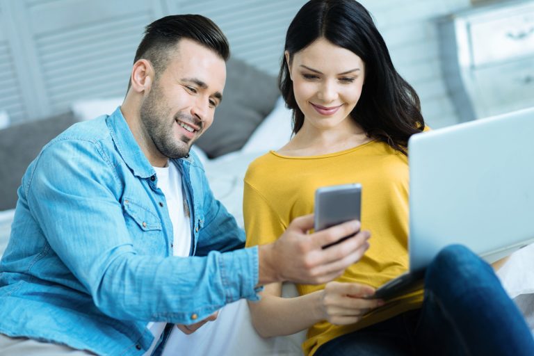 Un couple détendu regardant des photos sur un téléphone intelligent