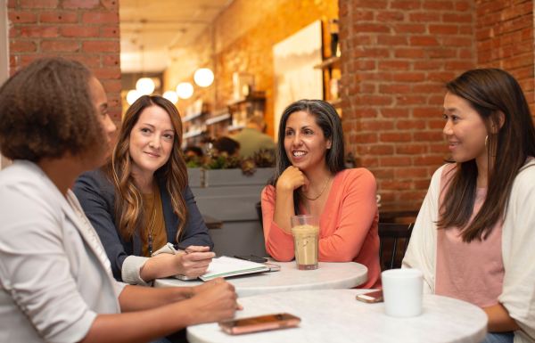 Groupe de personnes assises à une table en train de discuter