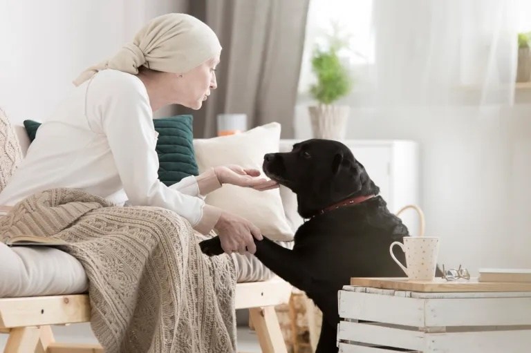 une femme atteinte d'un cancer qui joue avec son chien