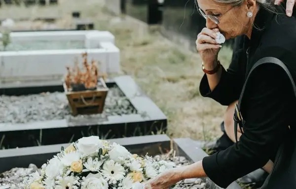 une femme en deuil devant une tombe