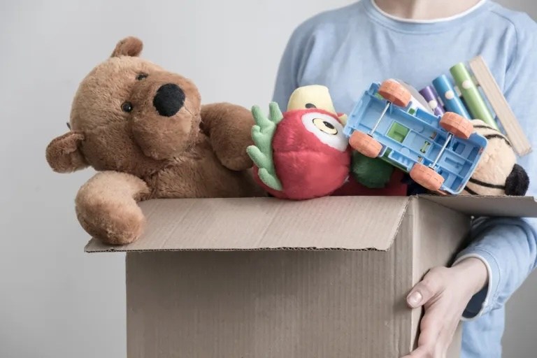 tenant une boîte de jouets