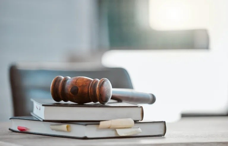 un marteau de juge posé sur le banc du juge
