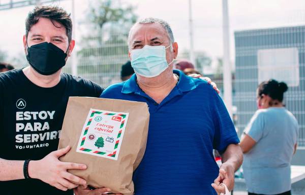 un bénévole remettant un sac de dons à un membre de la communauté