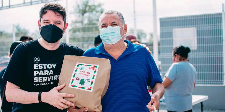 un bénévole remettant un sac de dons à un membre de la communauté