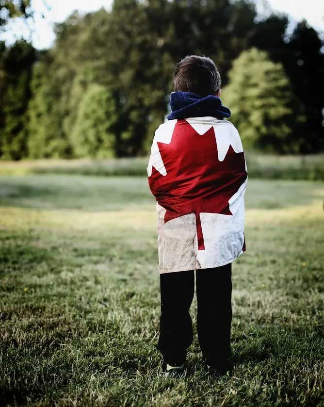 Un garçon portant un drapeau canadien