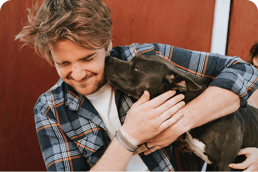 Un propriétaire de chien en train de serrer son chien dans ses bras