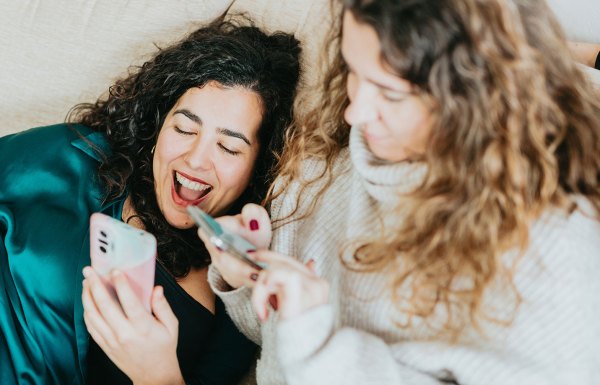 Deux amis utilisent leurs téléphones pour faire défiler les réseaux sociaux