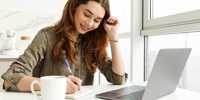 una donna sorridente che scrive una lettera
