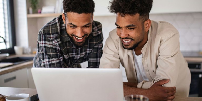 Due amici che usano un computer portatile per aggiornare la loro raccolta fondi