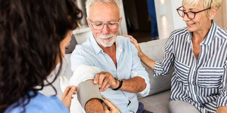 Un uomo che si fa misurare la pressione da un medico